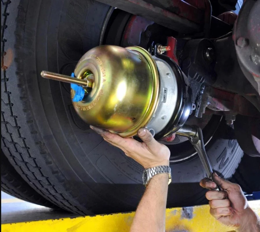 Mechanic servicing a truck's wheel assembly